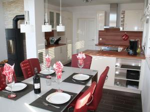 a kitchen with a table and red chairs in a kitchen at Villa Kiek Ut in Trent