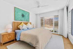 une chambre avec un grand lit et une fenêtre dans l'établissement Luxe at Alex - Your Coastal Retreat Awaits, à Alexandra Headland 24 autres photos