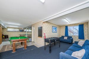 a living room with a pool table and a blue couch at Ocean Vista Large Modern Home With Ocean Views in Guilderton