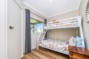 a bedroom with two bunk beds and a desk at Coastal Pine in Guilderton