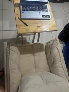 a table with a laptop on top of a couch at Pousada Hostels Foryou in Ibiraçu +80 photos