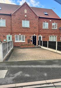a brick house with a driveway in front of it at Willow Cottage in North Muskham