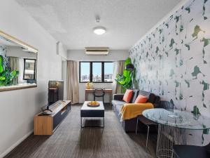 una sala de estar con un sofá y una mesa en Central Brunswick Apartment Hotel, en Brisbane