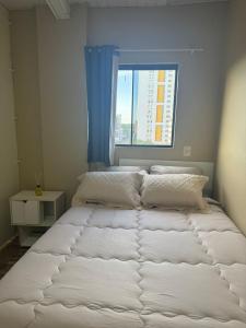 una cama grande en una habitación con ventana en Central Urbano CDE, en Ciudad del Este