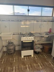 una cocina con estufa y fregadero en Central Urbano CDE, en Ciudad del Este