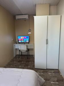 Un dormitorio con una cama, un escritorio y un televisor. en Central Urbano CDE, en Ciudad del Este 23 fotos más