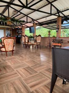 a room with chairs and a table and a wooden floor at Villa Pospon in Buga