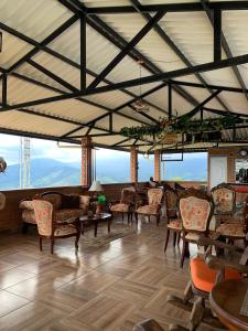a large room with chairs and tables and a large window at Villa Pospon in Buga