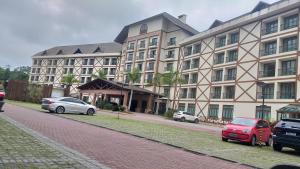 un grande edificio con auto parcheggiate di fronte di Flat lindo em pedra azul a Pedra Azul