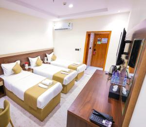 a hotel room with two beds and a television at فندق بارك الياس in Aţ Ţunḑubāwī