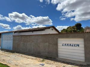 a garage with two white garage doors on it at Pousada Praça da Bíblia - Santa Maria da Vitória in Santa Maria da Vitória +10 photos