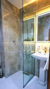a bathroom with a shower and a sink at فندق بارك الياس in Aţ Ţunḑubāwī