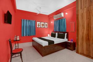 a red bedroom with a bed and a chair at Hotel O Patliputra Railway Station Formerly Rameshwaram Guest House in Dānāpur +45 photos