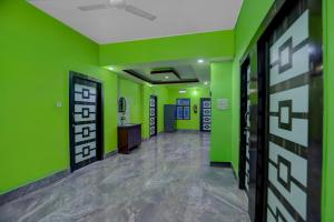 an empty corridor with green walls and a hallway with doors at Hotel O Patliputra Railway Station Formerly Rameshwaram Guest House in Dānāpur