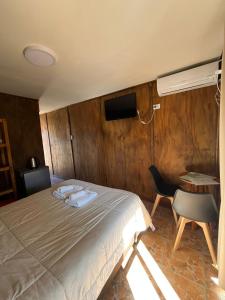 een slaapkamer met een bed, een bureau en een stoel bij Village in La Cumbrecita