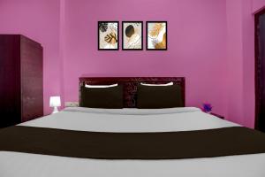 a bedroom with a large bed with pink walls at Hotel O Patliputra Railway Station Formerly Rameshwaram Guest House in Dānāpur