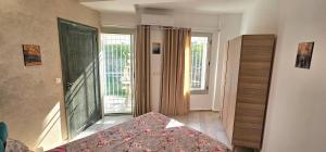 a bedroom with a bed and a door to a balcony at Le Havre de Paix in Nabeul