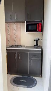 a small kitchen with a stove and a microwave at MD Homes and Shortlet in Lagos