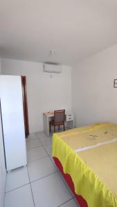 a bedroom with a bed and a table and a desk at Quarto privativo in São-José-do-Ribamar