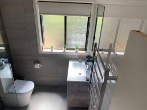 une salle de bain avec toilettes, lavabo et fenêtre dans l'établissement Centre31, à Evergreen 3 autres photos