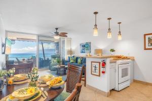 a kitchen and living room with a table and chairs at Kulakane 211 · KK 211 Updated OceanFront Whale Watching in Kahana