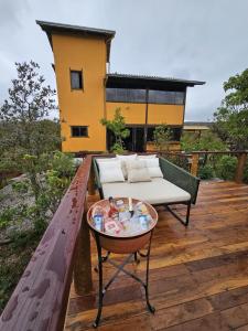 a patio with a couch and a table on a deck at Morada da Terra Lapinha da Serra in Santana do Riacho