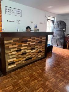 a man standing behind a counter in a room at ENEDE HOSTEL in Cusco