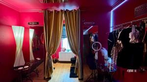 een kamer met rode muren en een kamer met gordijnen bij Fantastic Naughty Corner in Brighton & Hove