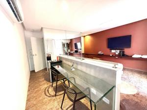 a hotel room with a bar and a tv at Sensacional Suíte no Union no Jacaré! in Ilha da Restinga