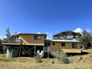 a large yellow house with a porch and balcony at Condon 53 in Evergreen
