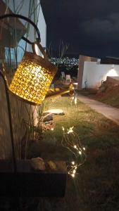 a lamp sitting on the grass in a yard at night at Anima Lodge in Villa Carlos Paz +17 photos