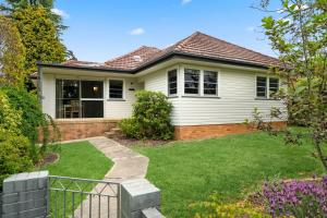a white house with a fence in a yard at Balgownie Cottage in Blackheath