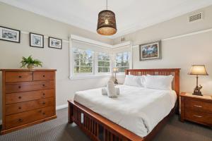 a bedroom with a large bed and a dresser at Balgownie Cottage in Blackheath