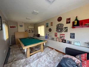 Una sala de estar con una mesa de billar. en Hermosa casa amoblada en barrio privado, en Yerba Buena