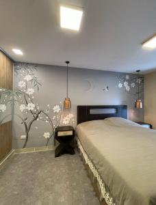 Un dormitorio con una cama y una pared con flores. en Hermosa casa amoblada en barrio privado, en Yerba Buena