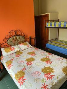 a bedroom with a bed with a flowered blanket at Complejo Turístico Tierra Dorada in Manta