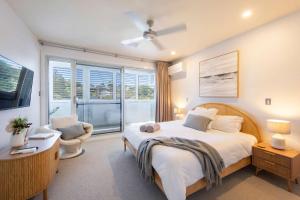 Un dormitorio con una cama grande y una ventana grande en Penthouse on the Ritz - Oceanstays, en Yamba