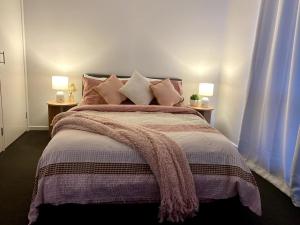 a bedroom with a large bed with pillows at Bella's Beach House in Venus Bay