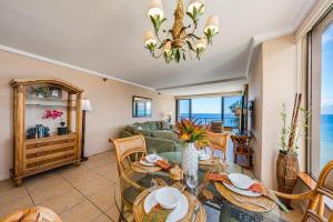 a living room with a table and chairs and the ocean at Maui Kai 808 · MK 808 OceanFront 1BD Kaanapali Beach Ocean Views in Lahaina