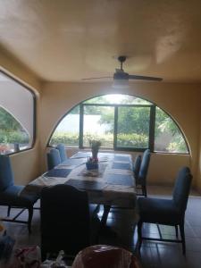 ein Esszimmer mit Tisch und Stühlen und einem großen Fenster in der Unterkunft Cuarto 2 casa Mixtecos in Puerto Escondido