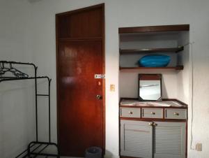 ein Zimmer mit einer Tür und einem Spiegel und einem Regal in der Unterkunft Cuarto 2 casa Mixtecos in Puerto Escondido