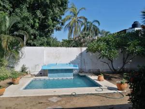 ein Swimmingpool in einem Hof neben einer Mauer in der Unterkunft Cuarto 2 casa Mixtecos in Puerto Escondido