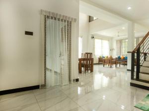 a living room with a staircase and a dining room at Ivy Garden Retreat in Gampola