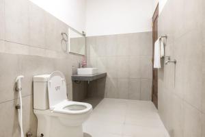 a white bathroom with a toilet and a sink at Ivy Garden Retreat in Gampola +17 photos