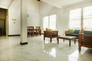 a living room with couches and tables and windows at Ivy Garden Retreat in Gampola