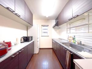 上富良野町にあるNorth Furano Houseのシンクと冷蔵庫付きのキッチン