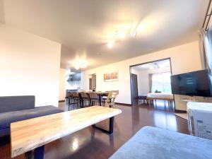 上富良野町にあるNorth Furano Houseのソファとテーブルと椅子のあるリビングルーム