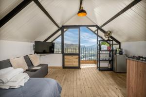 a room with a bed and a tv and some windows at Aurora Ecoliving Finca a 30 minutos de Medellín in Girardota