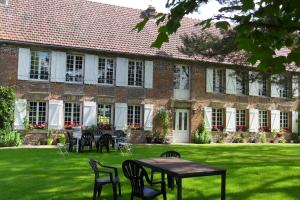 a brick building with tables and chairs in the yard at Chambres d'hôtes Manoir du Buquet in Honfleur