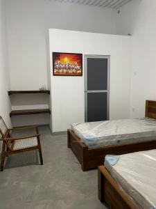 a bedroom with two beds and a painting on the wall at N28 Negombo in Negombo